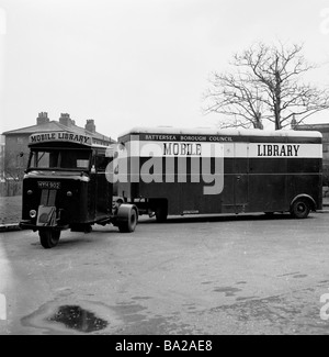 1950s, storica, una biblioteca mobile, collegata ad un veicolo a motore a tre ruote, parcheggiata all'esterno di una proprietà immobiliare, Battersea, Londra del Sud, Inghilterra, Regno Unito. Foto Stock