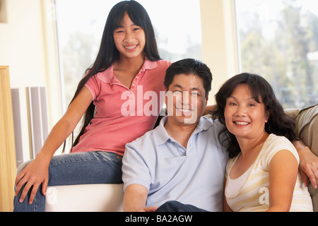 Famiglia seduti insieme a casa Foto Stock