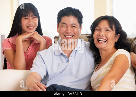 Famiglia seduti insieme a casa Foto Stock