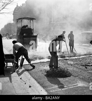 1950s, operai francesi che posano catrame caldo per riparare la superficie stradale di Boulevard Haussmann a Parigi, Francia, un lungo viale creato da Napoleone III Foto Stock