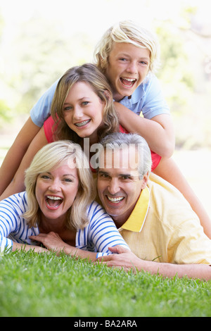 La famiglia che giace al di sopra di ogni altro in un parco Foto Stock