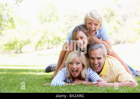 La famiglia che giace al di sopra di ogni altro in un parco Foto Stock