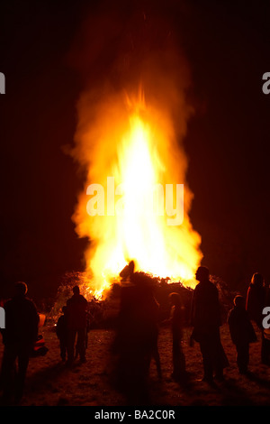 Persone in piedi intorno a un falò di notte Foto Stock