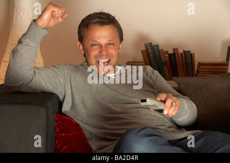 Uomo di guardare la televisione eccitato Foto Stock