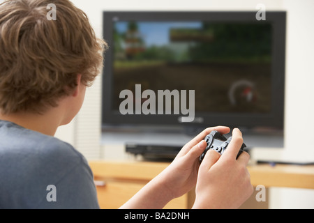 Ragazzo adolescente giocando con una console di gioco Foto Stock