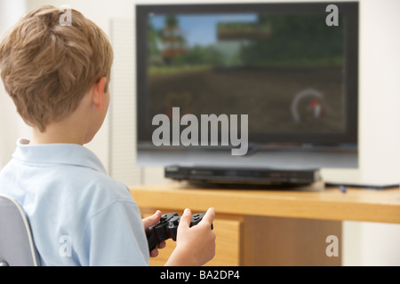 Giovane ragazzo giocando con una console di gioco Foto Stock