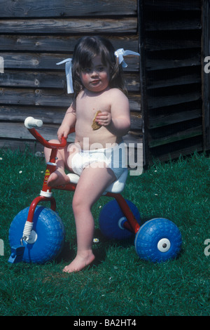 Bambina con giù la sindrome s sul suo trike Foto Stock