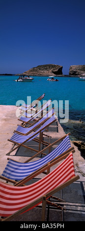 Una riga vuota di sedie a sdraio alla Laguna Blu di Comino. Malta. Foto Stock