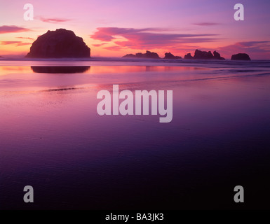 Sunset silhouettes faccia Rock al Bandon Beach. Foto Stock
