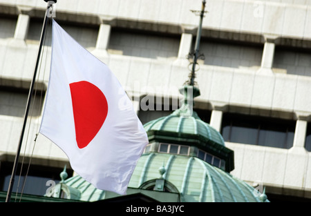 Una bandiera giapponese la Hinomaru vola al di fuori della Banca del Giappone a Tokyo Foto Stock