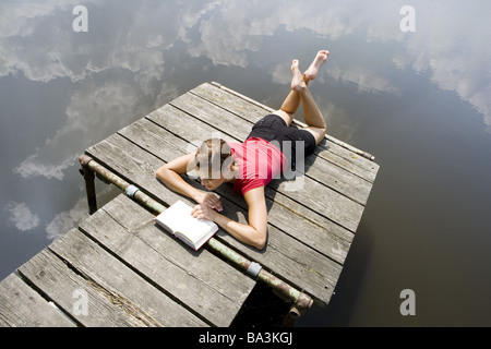 Donna giovane libro legge bridge si trova acqua-riflessione superficiale cloud-cielo persone serie abbastanza-corpi 24 anni 20-30 anni Foto Stock