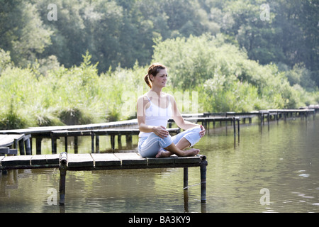 Giovane donna siede a ponte su misura serie sedile persone abbastanza-corpi 24 anni 20-30 anni dai lunghi capelli bruna ABBIGLIAMENTO SPORTIVO ABBIGLIAMENTO SPORTIVO Foto Stock