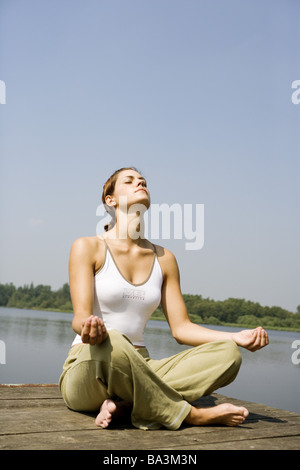 Donna giovane bridge si siede la meditazione-pratica persone serie abbastanza-corpi 24 anni 20-30 anni brunette barefoot tailor-sede Foto Stock