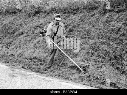 Ottanta, foto in bianco e nero, economia, lavoro, occupazione, giardinaggio, paesaggio giardiniere mows l'erba su un pendio, età 40-50 anni, Foresta Nera, Baden-Wuerttemberg Foto Stock