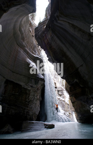 Scalatore femmina esplora arrampicata su ghiaccio nella si restringe al Canyon Maligne nel Parco Nazionale di Jasper, Alberta, Canada Foto Stock