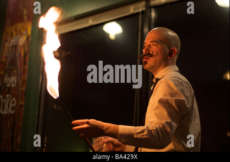 Maschio mangiatore di fuoco guarda in fiamme di fuoco durante la performance sul palco a Coney Island, New York (per solo uso editoriale) Foto Stock