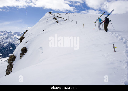 Highland-albero neve fresca sciatore-interna va in salita porta sci back-parere montagne serie persone le donne a basso snow-Hillside Foto Stock