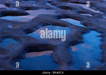 I piccoli stagni su roccia reflecing moody sky Foto Stock