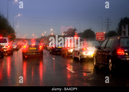 I driver di Vista occhio di accodamento del traffico su una pioggia inzuppato autostrada durante la serata rush hour in Inghilterra in Europa Foto Stock