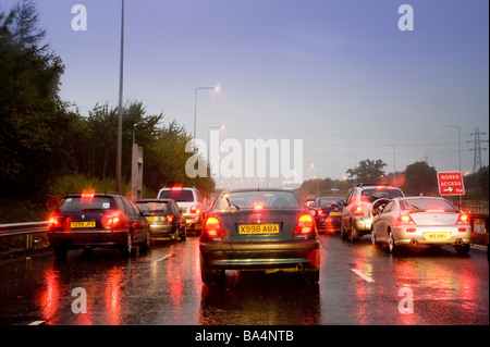 I driver di Vista occhio di accodamento del traffico su una pioggia inzuppato autostrada durante la serata rush hour in Inghilterra in Europa Foto Stock