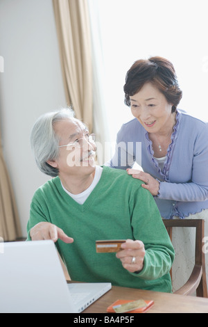 Senior uomo mostra portatile a sua moglie Foto Stock