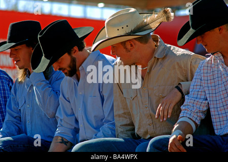 Cowboy in appoggio su una rotaia di recinzione tra tra bull rider eventi al Texas State Fair rodeo Foto Stock