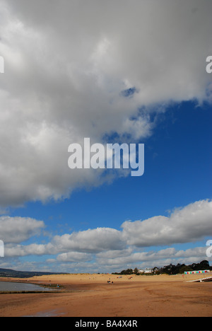 Guardando a Exmouth beach con una drammatica sky con dune di sabbia in lontananza, Devon, Inghilterra Foto Stock