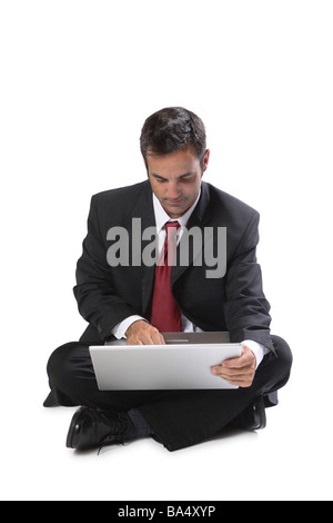 Imprenditore seduto con computer portatile isolato su bianco Foto Stock