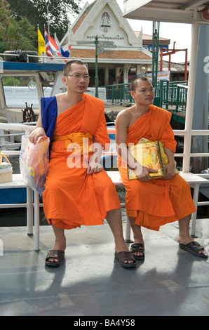 Due monaci buddisti di sedersi su un fiume taxi a Bangkok in Tailandia Foto Stock