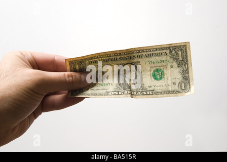 Mano che tiene una banconota del dollaro contro uno sfondo bianco Foto Stock