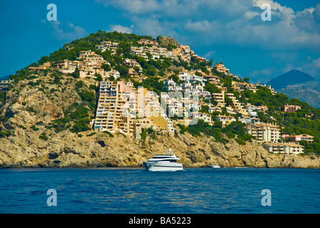 Case sulla scogliera e yacht in ingresso al porto di Andratx Maiorca Baleares Spagna | Häuser un einer Klippe und eine Yacht Foto Stock