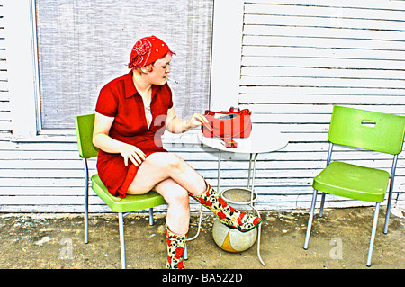 Classe media lady in bright red dress udienza del Vittoriano stile architettonico portico anteriore di fumare Foto Stock