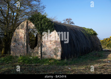 Vecchio abbandonati stagno e mattone guerra mondiale due nissen quonset hut sulla terra di rifiuti ormai abbandonato dalla ex seconda guerra mondiale airbase nella contea di Antrim Foto Stock