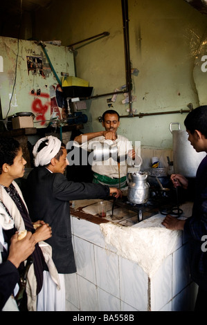 Un commerciante versando il tè a un tè stallo nella città vecchia di Sana'a, Yemen. Foto Stock