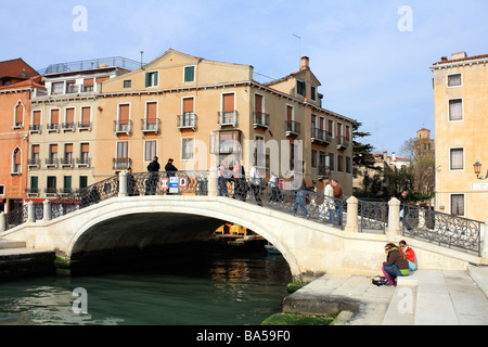 Bassa ponte ad arco attraverso canale sulla Riva degli Schiavoni waterfront a Venezia, Italia, Europa. Foto Stock