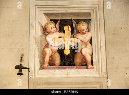 Tromp l'oeil dettaglio murale di putti recanti una croce dorata nella chiesa di Santa Maria in Gradi. Arezzo, Toscana, Italia Foto Stock