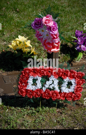 Fiori e un 'AD' memento decorare una tomba nel cimitero di Allegheny, Pittsburgh, Pennsylvania. Foto Stock