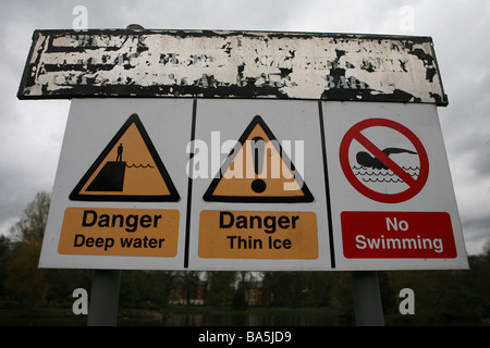 Pericolo in acqua profonda pericolo ghiaccio sottile e nessun segno di nuoto in un parco in Manchester Foto Stock