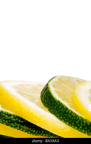 Una stretta verticale di una pila di succosa Fresh cut limone e fettine di lime con spazio per la copia Foto Stock