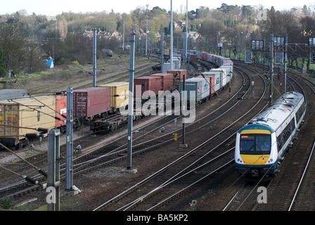 Passeggero servizio ferroviario che passa contenitore per trasporto carri, Ipswich, Suffolk, Regno Unito. Foto Stock