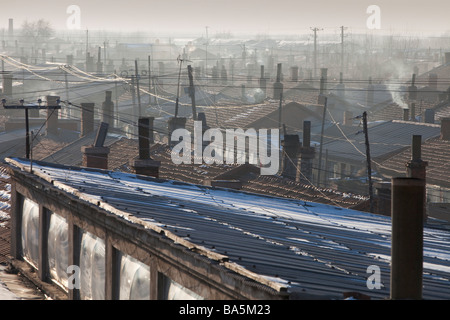 Terribile inquinamento atmosferico da carbone incendi e veicoli pende sopra baraccopoli nella città di Suihua Cina settentrionale Foto Stock