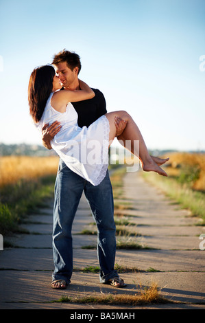 Giovane uomo Caring giovane donna in armi Foto Stock