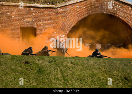 WW2 soldati tedeschi in scena di battaglia con fumo arancione schermo.fort nelson rievocazione storica evento Foto Stock