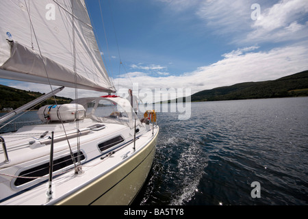 Un uomo in barca a vela un piccolo yacht nel Kyles of Bute nel Firth of Clyde Scozia Scotland Foto Stock