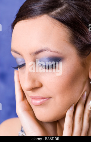 Giovane e bella donna che indossa un ombretto blu occhi chiusi Foto Stock