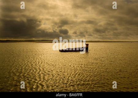 Pescatore che raccoglie le cozze a Blakeney Harbour Norfolk Foto Stock