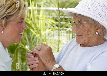 Senior-home terrazza sedia a rotelle senior keeper ride brocciata allegramente side-ritratto persone serie seniores donna 70-80 anni Foto Stock