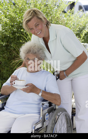 Senior-home terrazza sedia a rotelle senior di caffè in tazza keeper serie ride persone anziani donna 70-80 anni le bevande a base di caffè gode Foto Stock