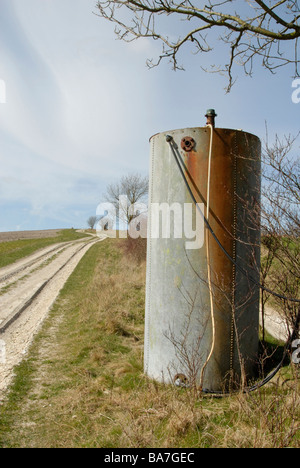 Vecchio fissata con rivetti in acciaio galvanizzato con serbatoio flessibili accanto a fattoria gessose sulla pista South Downs, NR, armamento West Sussex, in Inghilterra Foto Stock