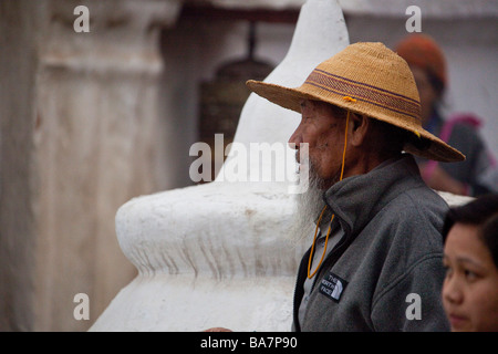 Pellegrini a Kathmandu Boudhanath pregando da statua e mulini di preghiera. Il Nepal Asia Foto Stock